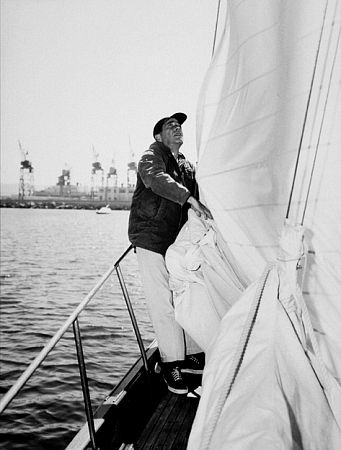 Letting out the sail on his yacht, 