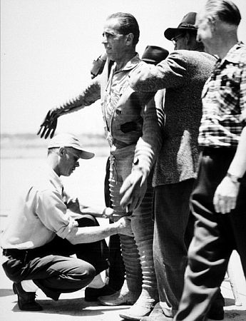 Humphrey Bogart with crew helping him into pilot suit for 