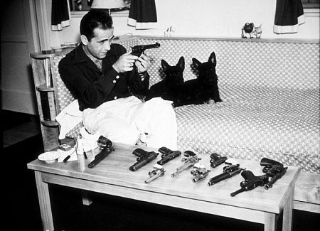 With his pet scottish terriers and gun collection at home, circa 1946.