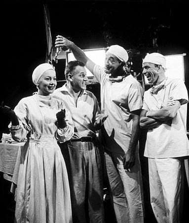 Stranley Kramer, director, with Olivia De Havilland, Robert Mitchum, and Frank Sinatra on the set of 