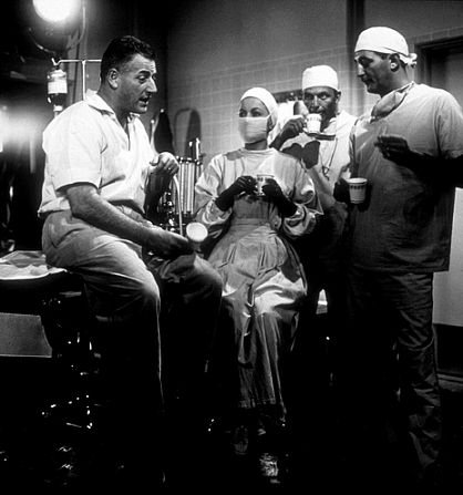 Stranley Kramer, director, with Olivia De Havilland, Frank Sinatra, and Robert Mitchum on the set of 