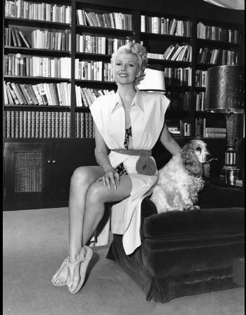 Rita Hayworth with her cocker spaniel, Poolkes in her Santa Monica home circa 1948