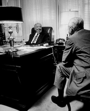 Alfred Hitchcock with writer Pete Martin at his office at Universal Studios, 7/25/57.