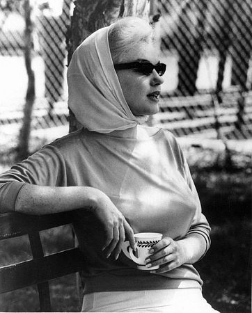 Marilyn Monroe sits in the Florida sun watching Joe Dimaggio in his new role as batting coach for the New York Yankees, 1961.
