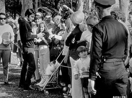 Elvis Presley signing autographs during a break from filming 