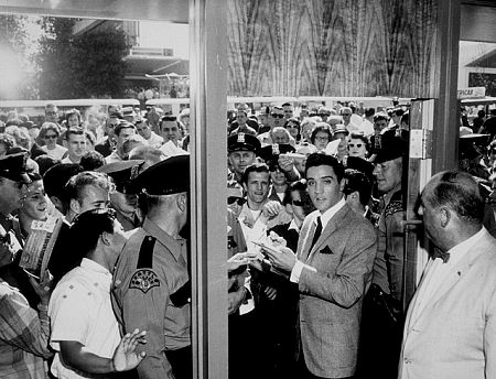 Elvis Presley signing autographs for his fans, 1961.