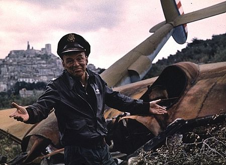 Frank Sinatra standing next to airplane wreckage for 
