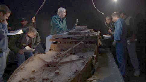 Using a scale model of the wreck of Titanic, James Cameron (center) plans the exploration sequence with his team, including MIR 2 pilot Genya Chernaiev (second from right, holding MIR scale model).