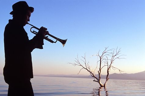 Tom (Val Kilmer) with his horn in silhouette at the Salton Sea.