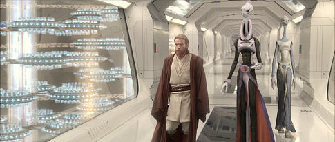 Jedi Obi-Wan Kenobi (actor Ewan McGregor) walks down a corridor, amazed by what he sees in the huge cloning facility on the planet Kamino. He is followed by Prime Minister Lama Su and aide Taun We.
