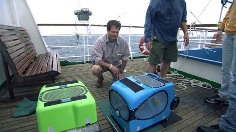 On deck of the Akademik Mistislav Keldysh, Bill Paxton (center) observes the ROV 'bots' nicknamed Jake (right; blue) and Elwood (left, green).
