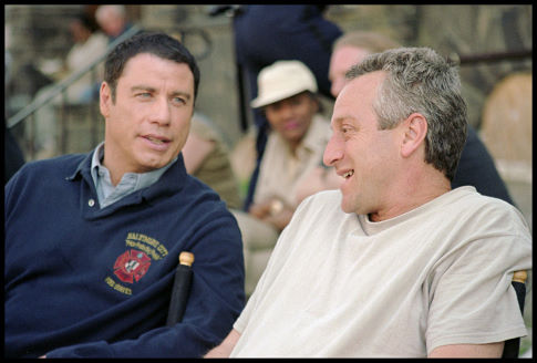 John Travolta (left) converses with producer Casey Silver (right) between takes on location in Baltimore.