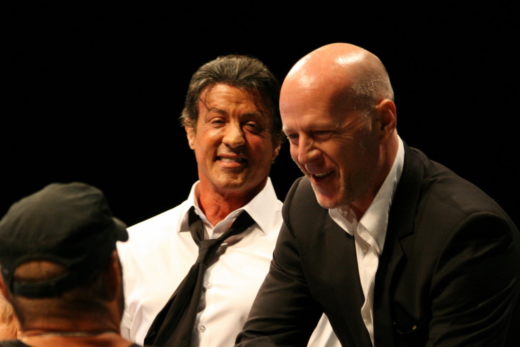 Bruce Willis shakes hands with Randy Couture during the Comic-Con 2010 Expendables panel