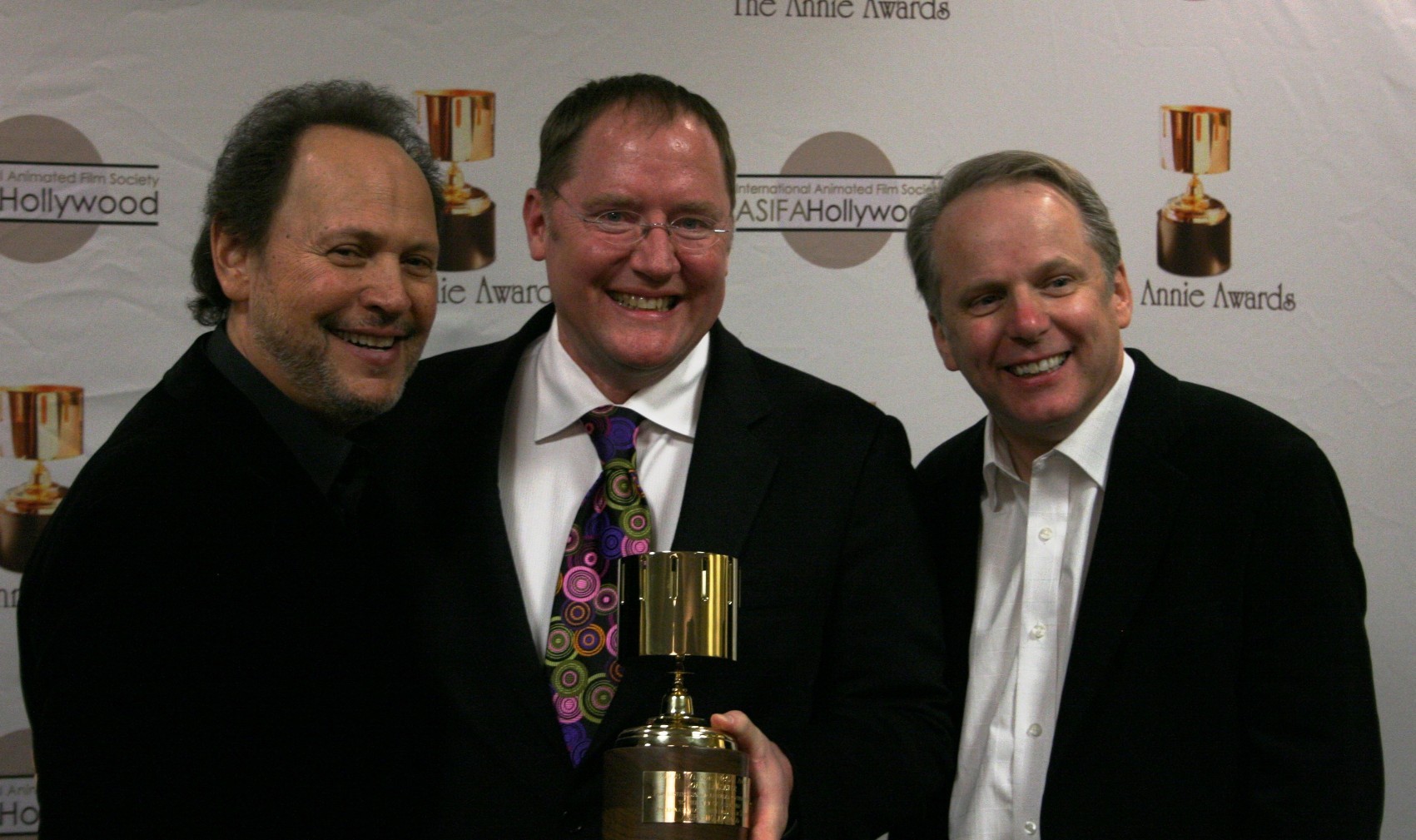 Presenter Billy Crystal congratulates Ub Iwerks award winners John Lasseter and Nick Park