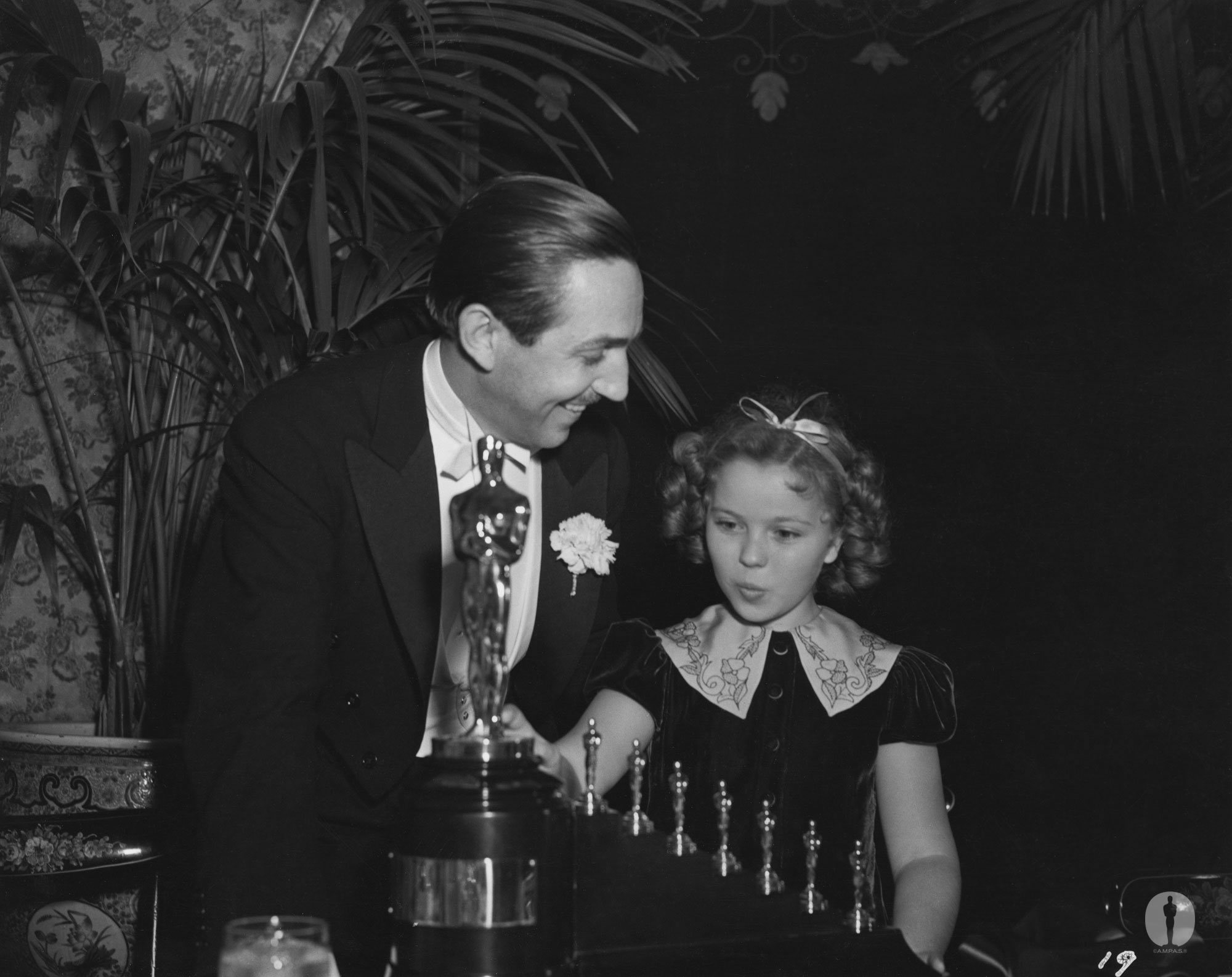 Walt Disney receives one statuette and seven miniature statuettes from Shirley Temple for 