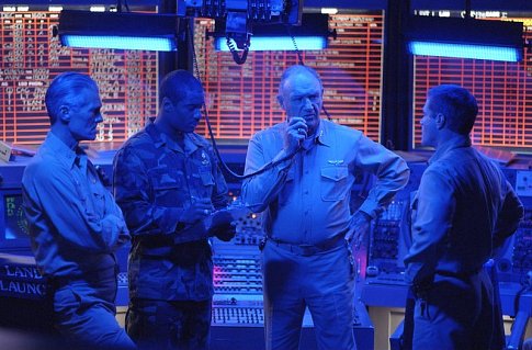 Reigart (GENE HACKMAN, center) communicates with a downed aviator, while planning a daring rescue mission with (left-right) the carrier commanding officer (TOM MOONEY), Rodway (CHARLES MALIK WHITFIELD) and O'Malley (DAVID KEITH).