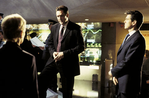 NSA Chief Falco (MICHAEL MADSEN, center) and James Bond (PIERCE BROSNAN, right) discuss strategy.