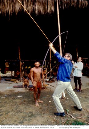 Peter O'Toole and his wife Sian Phillips visit the remote Venezuelian Waika tribe. Peter who is strong, found it almost impossible to draw the bow back, much to the enjoyment of Sian and the tribesman 1970 © 1978 Bob Willoughby