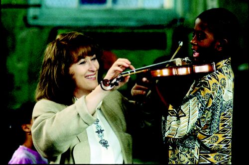 Roberta instructs a boy in playing the violin