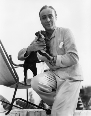 Charles Boyer holding his pet terrier, 
