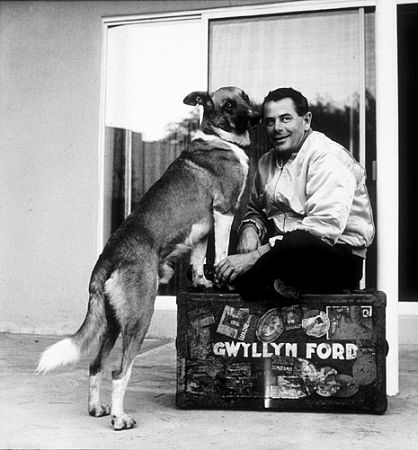 Glenn Ford with his pet dog at home, 1958.