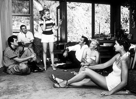 Rock Hudson at home playing charades with Leonard Stern (script writer), Lori Nelson (actress), Bob Preble (actor), Julia Adams (actress), and Betty Abbott (script girl), North Hollywood, CA, 1952.