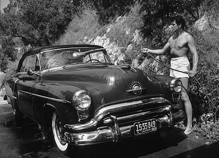 Rock Hudson washing his 1952 Oldsmobile outside of his Hollywood Hills Home