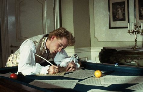 Mozart (TOM HULCE) composes music over a billiard table