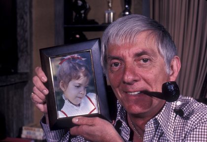 Aaron Spelling at home with a photograph of his daughter Tori Spelling