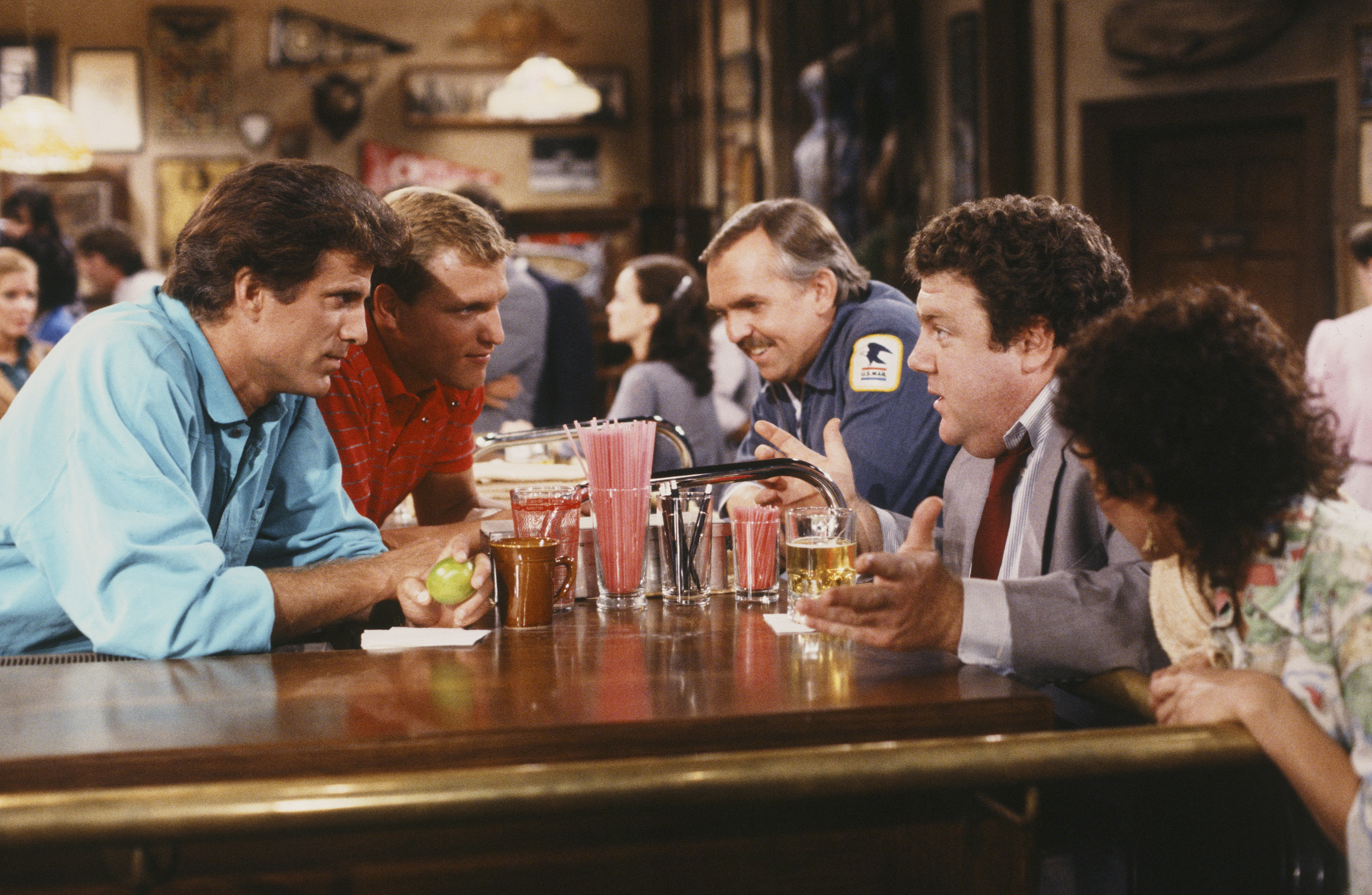 Still of Woody Harrelson, Ted Danson, John Ratzenberger, George Wendt, Johnny Gilbert and Rhea Perlman in Cheers (1982)