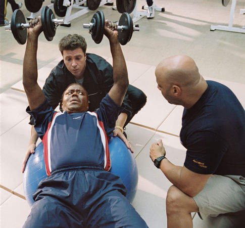 Stan Ross (Bernie Mac, lower left) hits the weight room with Boca (Michael Rispoli, upper left) and Brewers team conditioning coach (Scott Brooks, right) to prepare for his unlikely baseball comeback.
