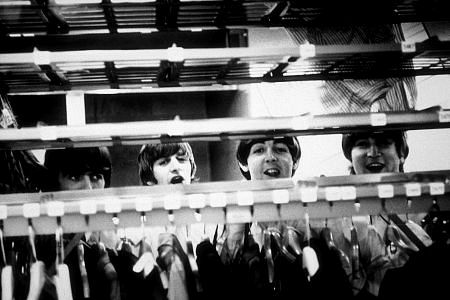 The Beatles (George Harrison, Ringo Starr, Paul McCartney,& John Lennon) peering through a clothes rack in Cleveland, OH, September 15, 1964