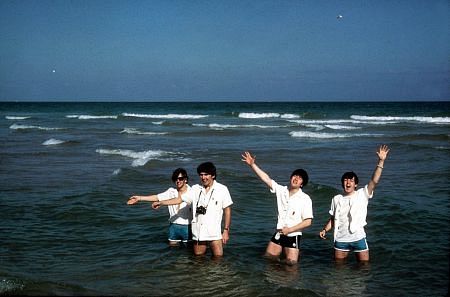 The Beatles (Ringo Starr, George Harrison, John Lennon, Paul McCartney) playing in the water.