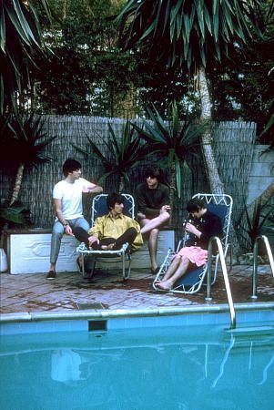 The Beatles (Paul McCartney, George Harrison, John Lennon, Ringo Starr relax along the poolside as Ringo fiddles with his camera, 1964