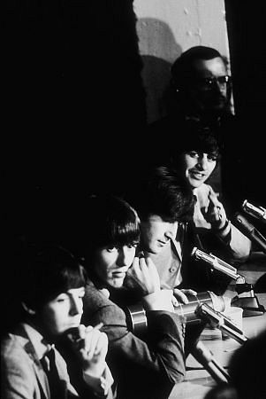 The Beatles (Paul McCartney, George Harrison, John Lennon, & Ringo Starr) at a press conference, c. 1964