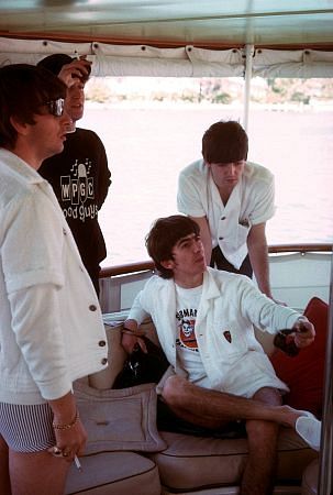 The Beatles (Ringo Starr, John Lennon, George Harrison, Paul McCartney) on board a boat.