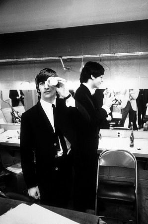 The Beatles (Ringo Starr and Paul McCartney inside their dressing room. Ringo with a cup covering his left eye) c.1964
