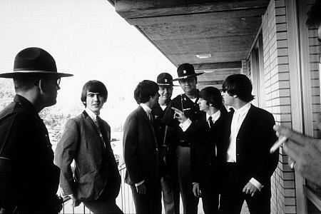 The Beatles (George Harrison, Paul McCartney, Ringo Starr, and John Lennon, accompanied by officials) c. 1964