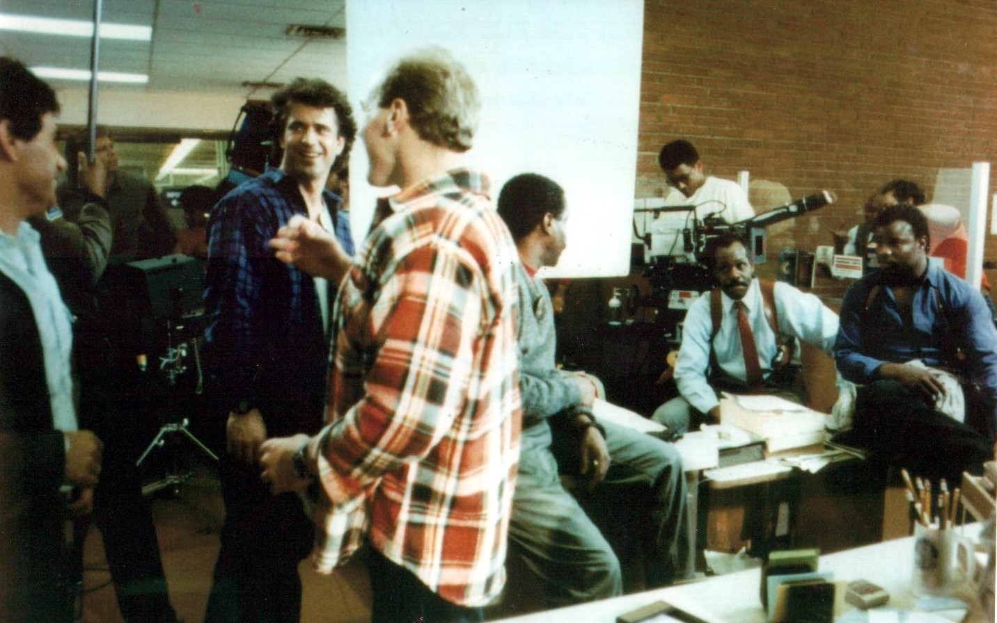 Mel Gibson, Danny Glover, Grand L. Bush and crew take a break during filming of LETHAL WEAPON II.