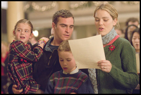 Linda (Jacinda Barrett, right) and Jack Morrison (Joaquin Phoenix, center left) share a tender moment with their children Katie (Brooke Hamlin, left) and Nicky (Spencer Berglund, center right) on Christmas Eve in Baltimore.