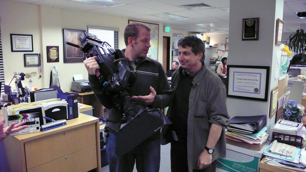 Paul Lieberstein explains the function of the camera to an editor.