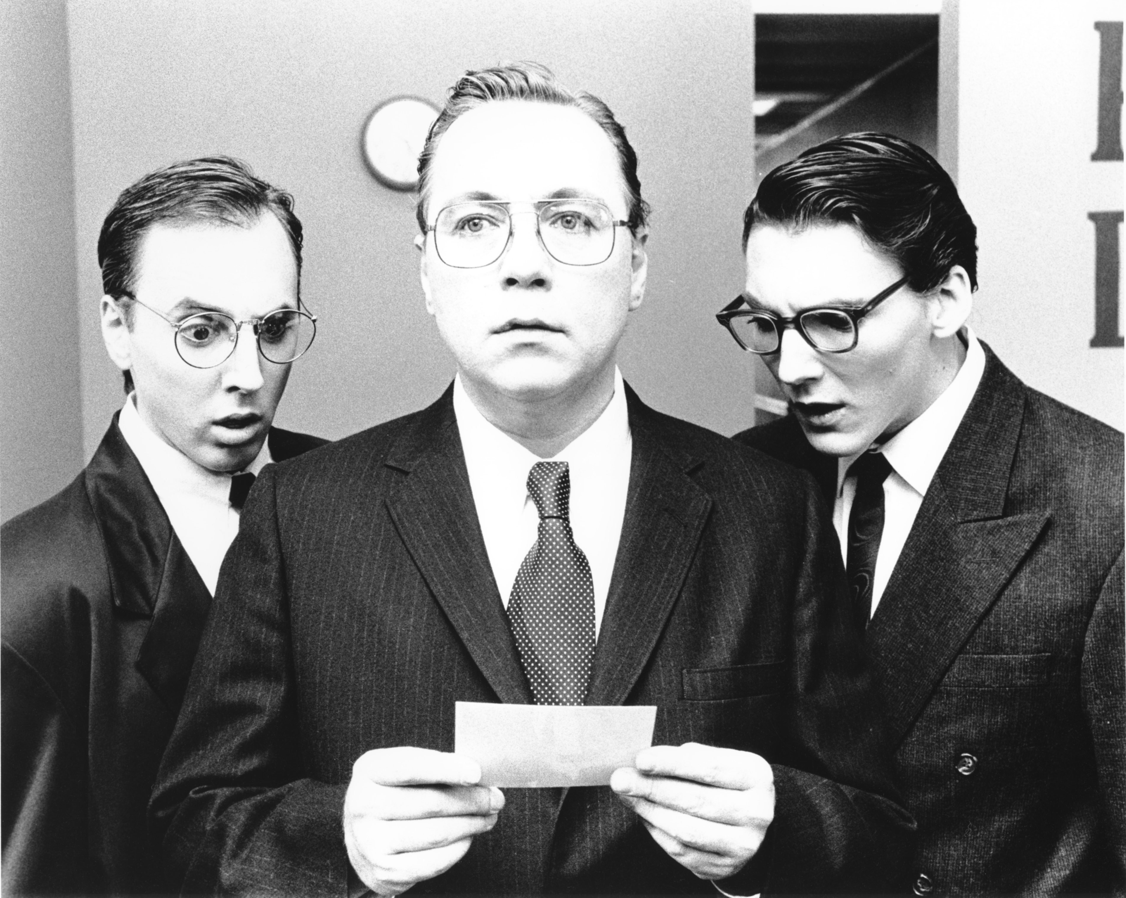 The Head Clerk (Robert Jodka) ponders the ramifications of a found photo while The Service Clerk (Jeff Corveau) and the Assistant Clerk (Eric Scheiner) express shock at what they see in a scene from filmmaker Angel Connell's 