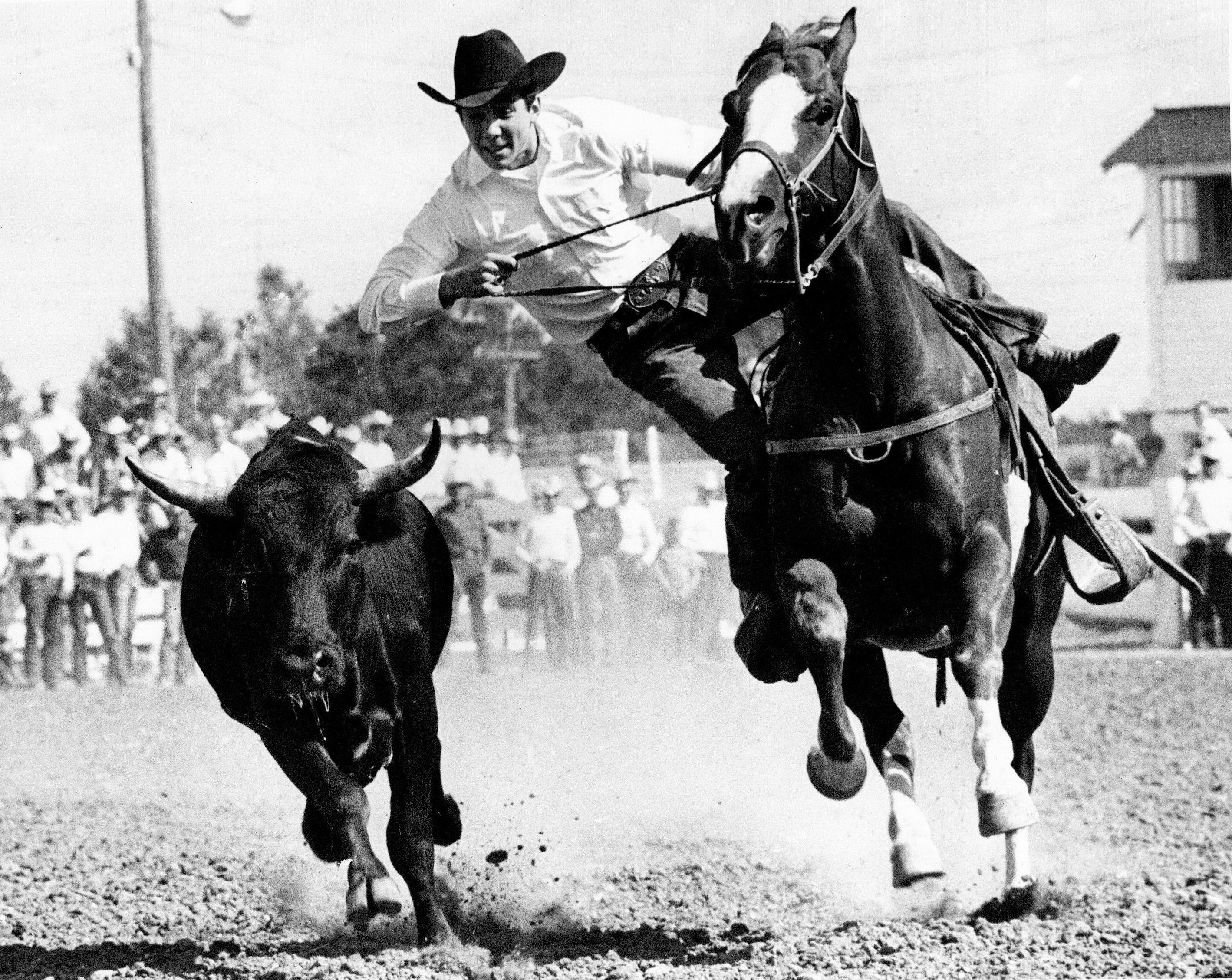 Johnny Crawford competes in steer wrestling at Cheyenne, Wyoming in 1965.