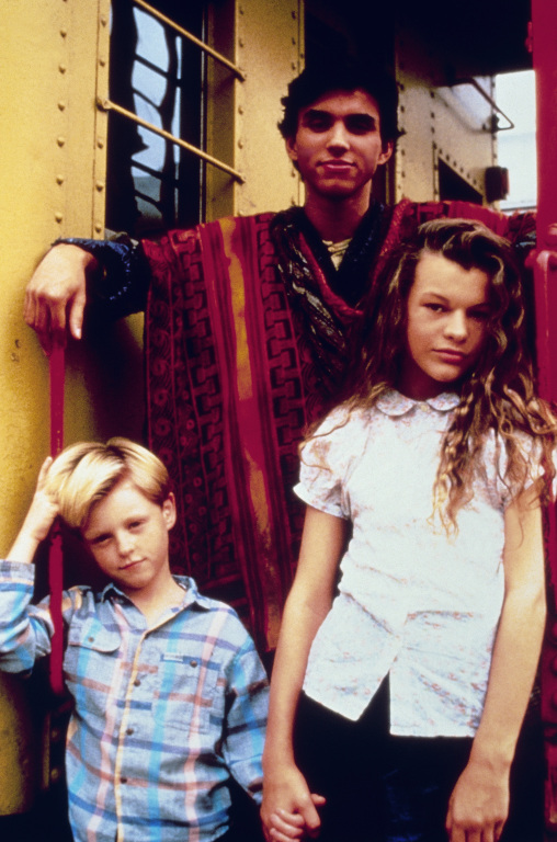 Promo Poster for 1988 film The Night Train to Kathmandu with Trevor Eyster, Eddie Castrodad and Milla Jovovich (from left to right)