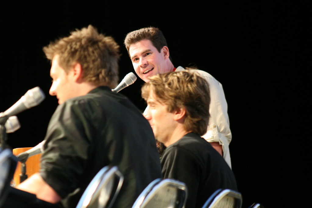 Ralph Garman (standing) moderates the District 9 panel, with director Neill Blomkamp (L) and lead actor Sharlto Copley.
