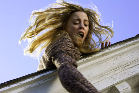 MELISSA GEORGE tries to save her daughter from falling off the roof in THE AMITYVILLE HORROR.