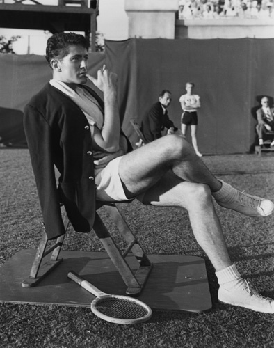 Farley Granger takes a well-earned breather after completing a day's shooting of tennis-playing scenes for 