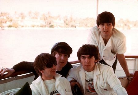 The Beatles, (Ringo Starr, John Lennon, George Harrison, Paul McCartney) on board a boat.