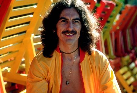 George Harrison in Acapulco posing near wooden lounge chairs, January 1977