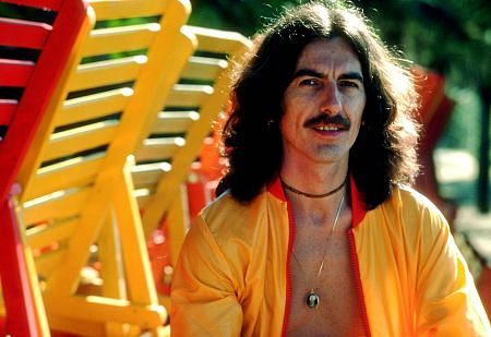 George Harrison in Acapulco posing near wooden lounge chairs, January 1977